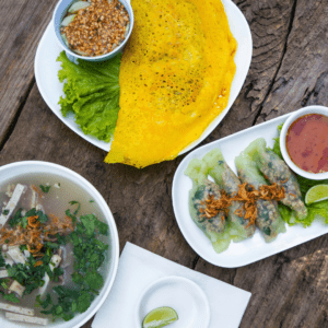 Assorted Thai dishes including crispy crepe, dumplings, and herb soup on a wooden table representing Thai cuisine popular at restaurants North of Boston