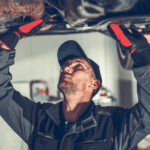 mechanic examining vehicle undercarriage during rust prevention undercoating service