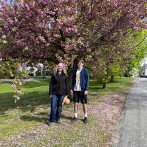 Mother and son celebrating Mother's Day with a walk around Horn Pond in Woburn, north of Boston, posing in front of a flowering tree