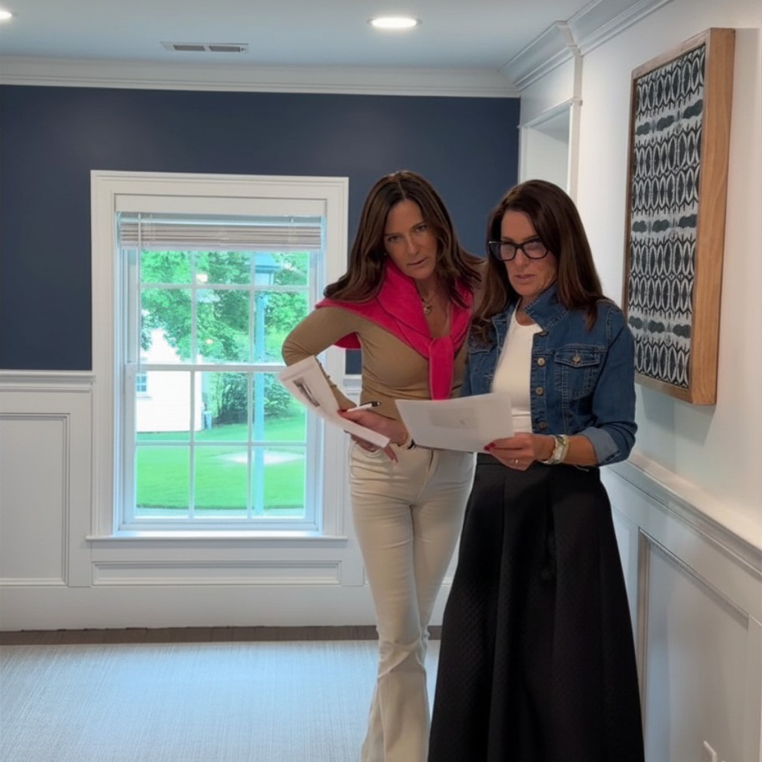 Clementine Interiors owners Maura Graham and Megan Worley reviewing a home staging report in a Melrose, MA home
