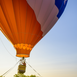 Colorful hot air balloon ride at a North of Boston summer festival, featuring a vibrant balloon preparing for takeoff during a local community event.
